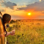 Kenya group trip for young travelers with a California influencer watching a stunning safari sunset in Kenya